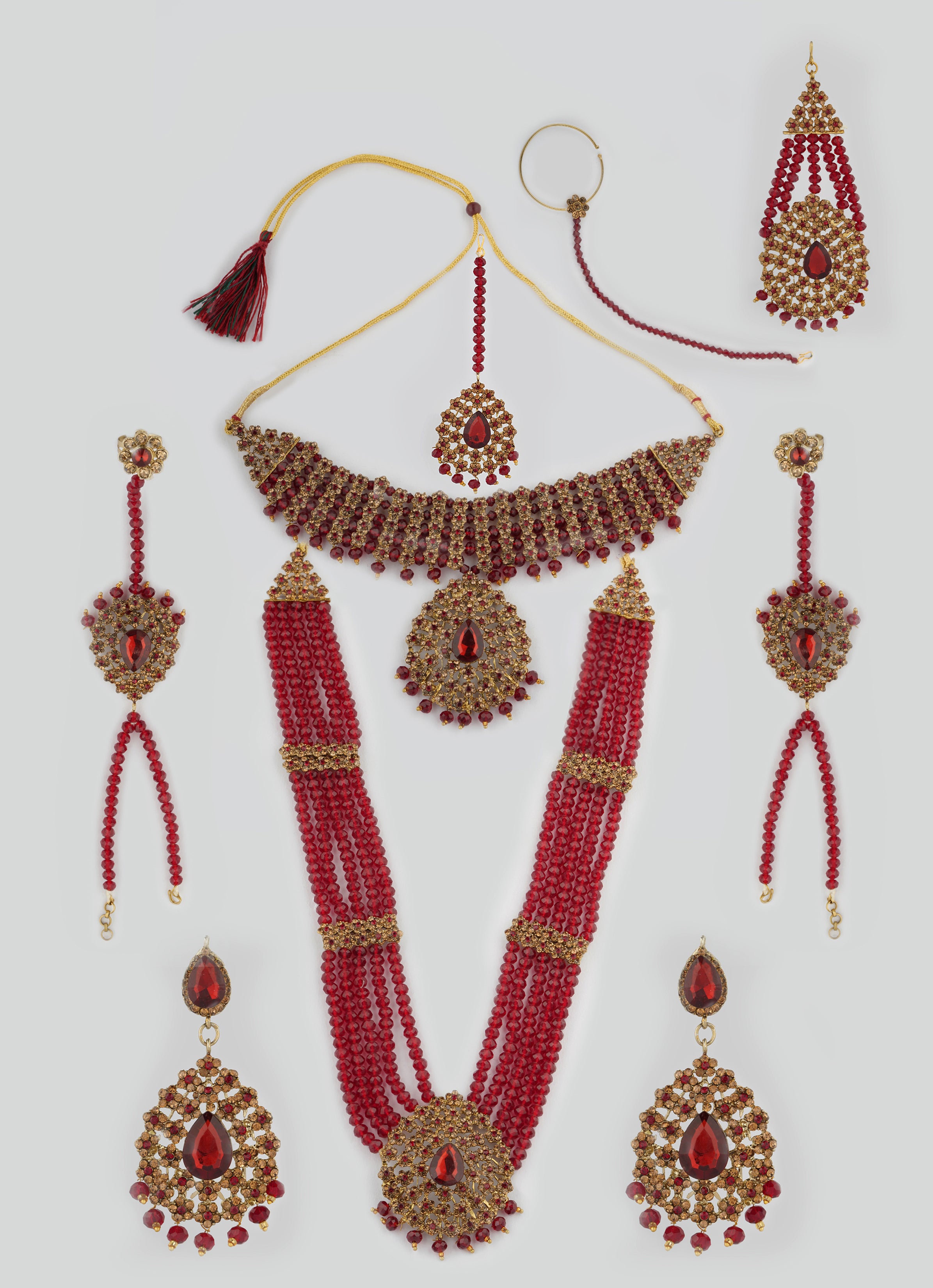 A maroon crystal stone bead necklace set with matching earrings, a nose ring, a panja, a tikka, and a passa. The set includes multiple necklaces with different lengths and a pair of earrings.