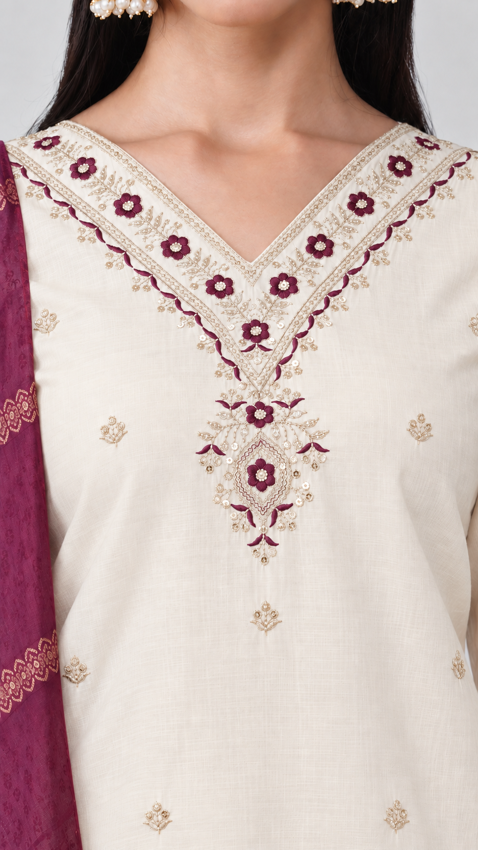 Cream-colored embroidered suit with a V-neckline, featuring burgundy and white gold floral embroidery, paired with a deep purple dupatta.