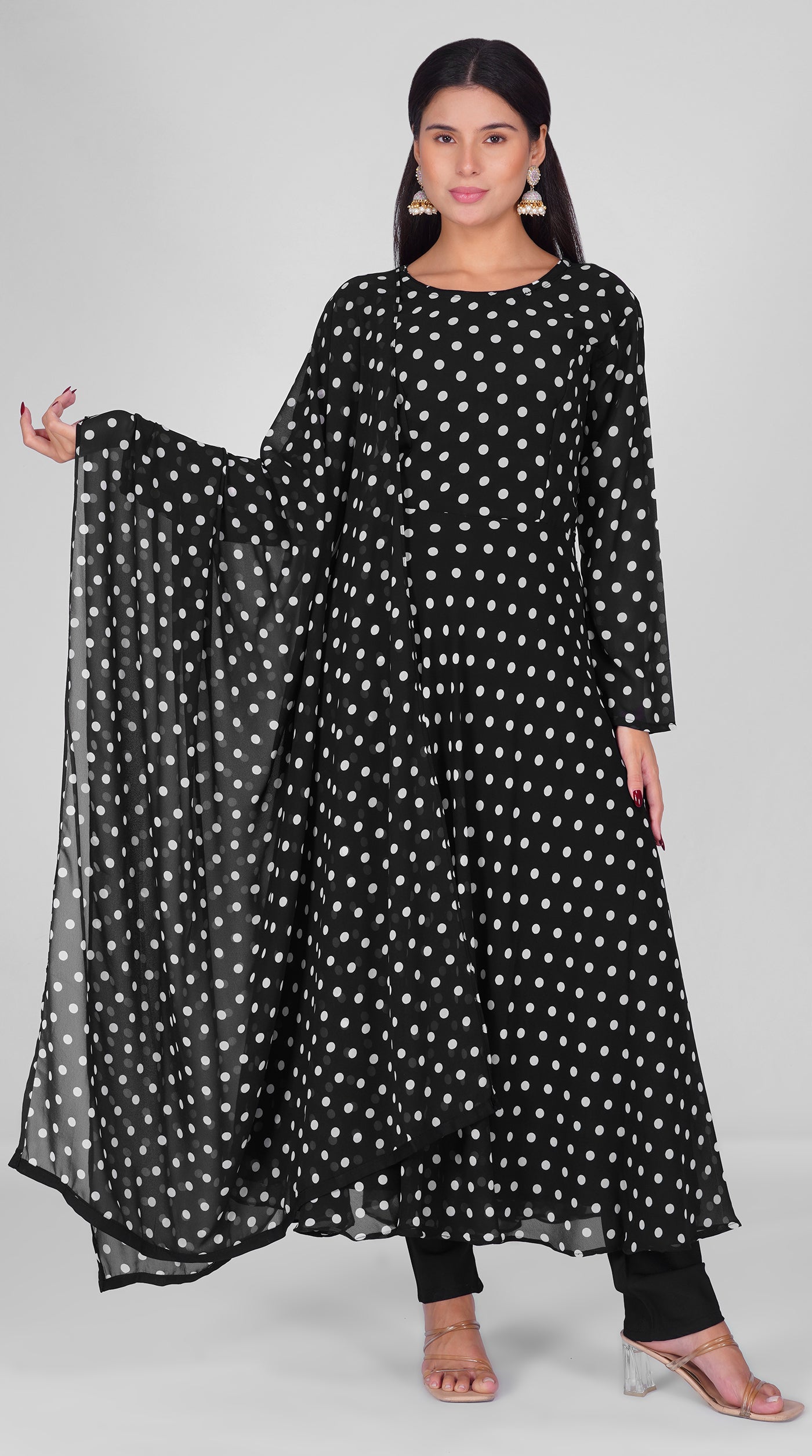 Woman wearing a black georgette bias cut suit set with white polka dot print, black crepe trousers, and matching printed georgette dupatta – Diya Online