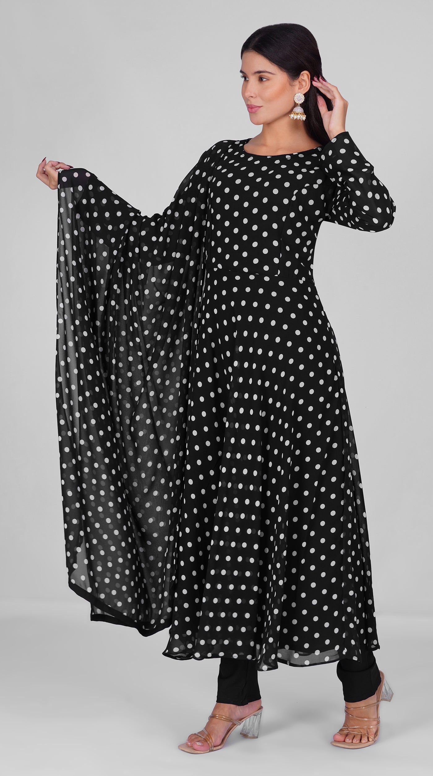 Woman wearing a black georgette bias cut suit set with white polka dot print, black crepe trousers, and matching printed georgette dupatta – Diya Online