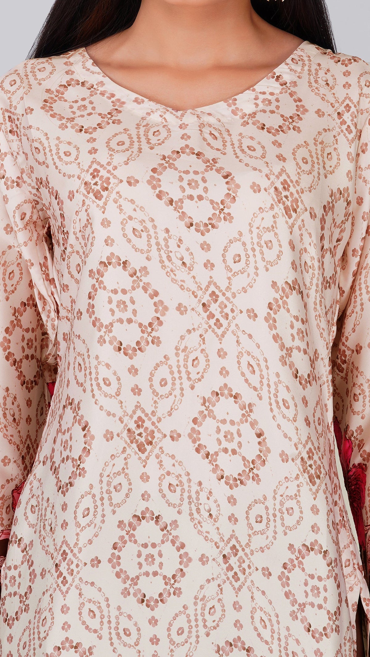 A close-up of a woman wearing a cream-colored kurta with a dusty rose geometric and floral block print pattern.