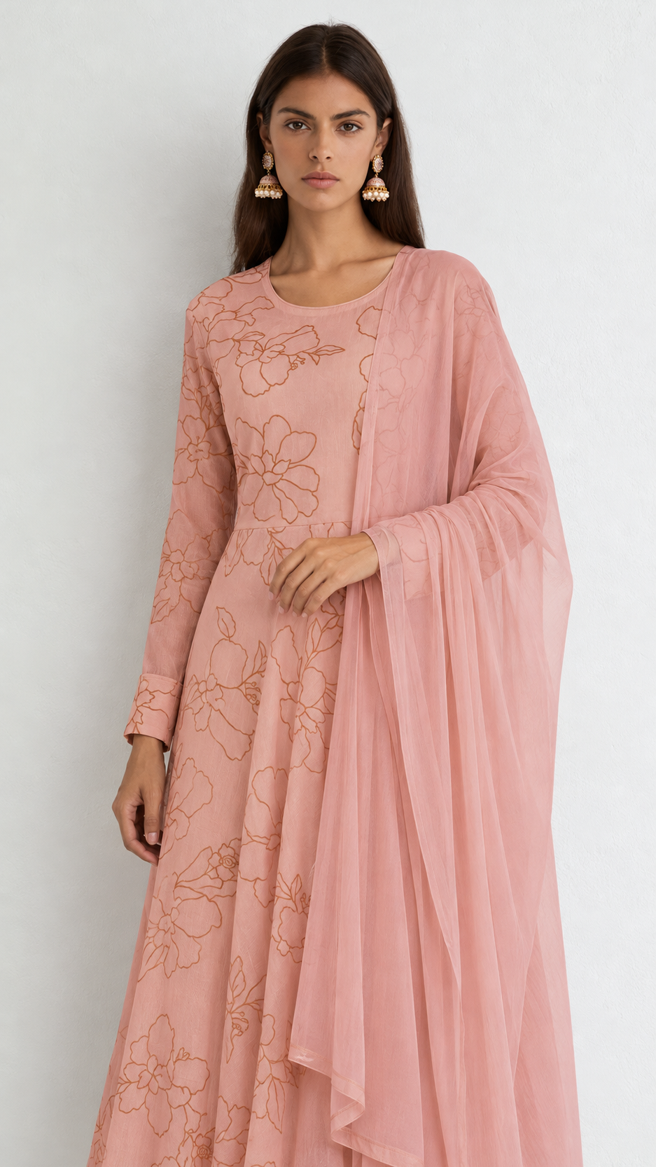 A woman modeling a dusty pink long kurta with floral embroidery and a matching sheer dupatta, set against a plain light gray background.