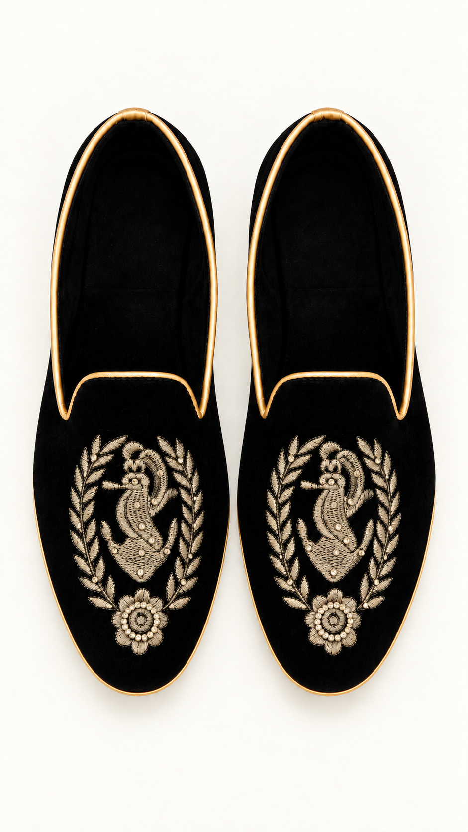 A pair of black velvet slip-on khussa with gold trim and detailed gold embroidery within a laurel wreath and a floral motif on the toe, shown against a plain white background.
