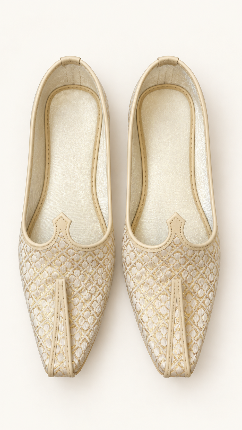A pair of beige and white brocade slip-on shoes with pointed toes
