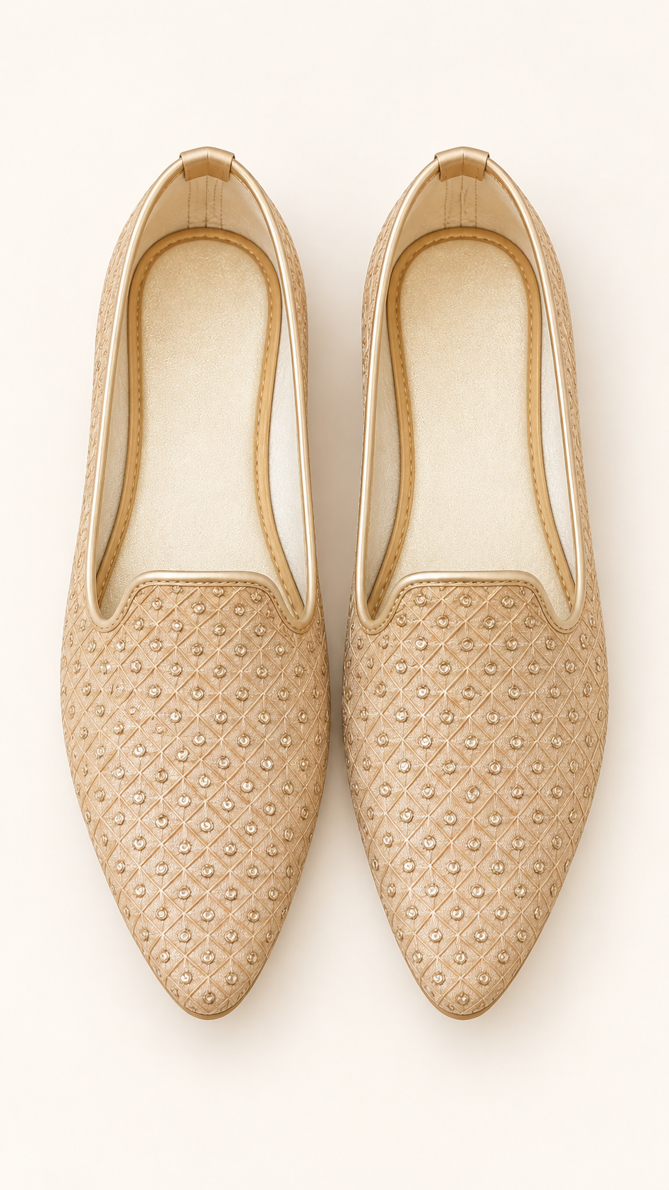 A pair of gold pointed-toe slip-on flats with an embroidered geometric pattern, shown from a top-down view on a light cream background.