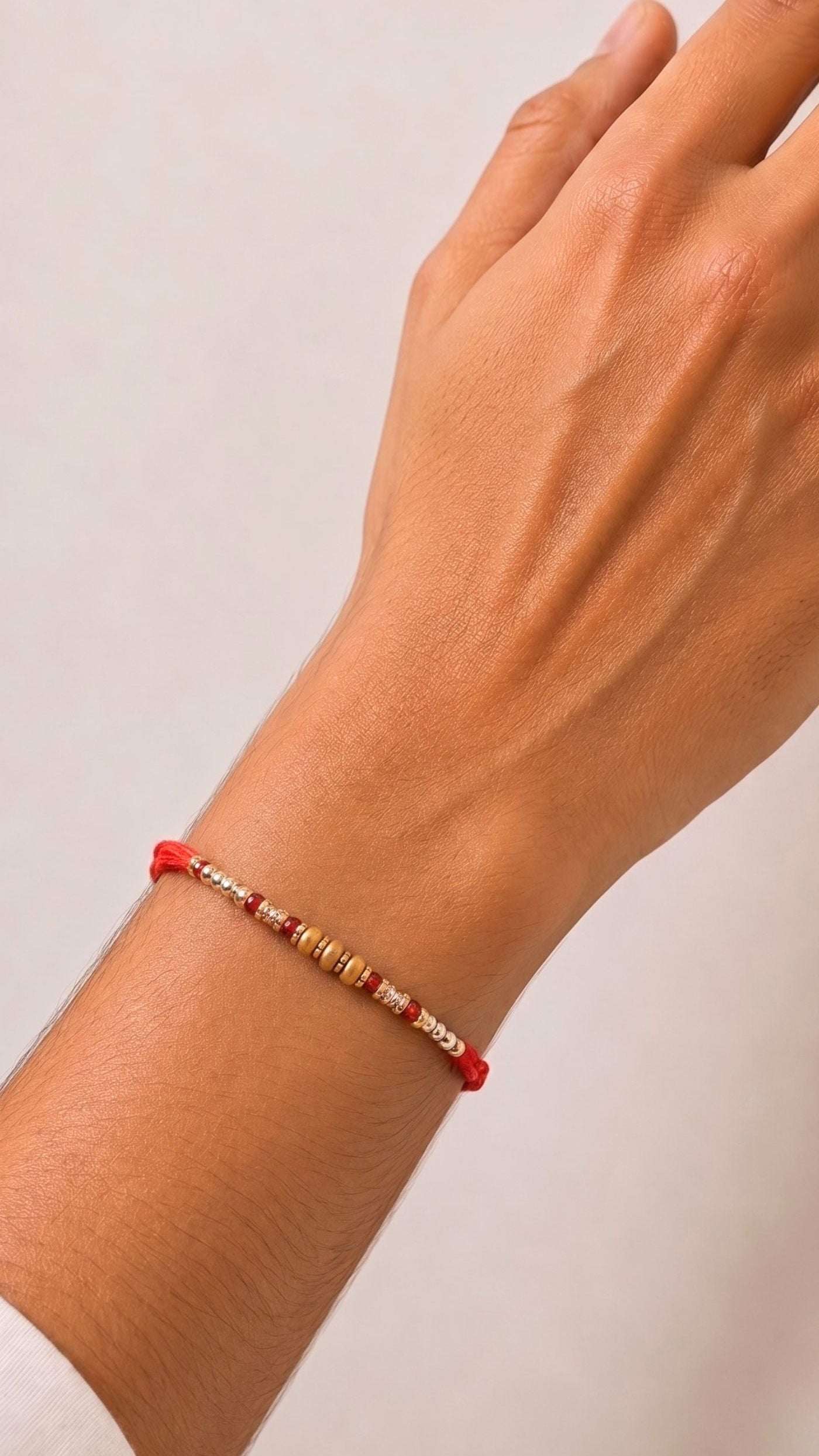 Red, pearl-effect and gold-tone beaded Rakhi with amber cylindrical centre beads – Diya Online