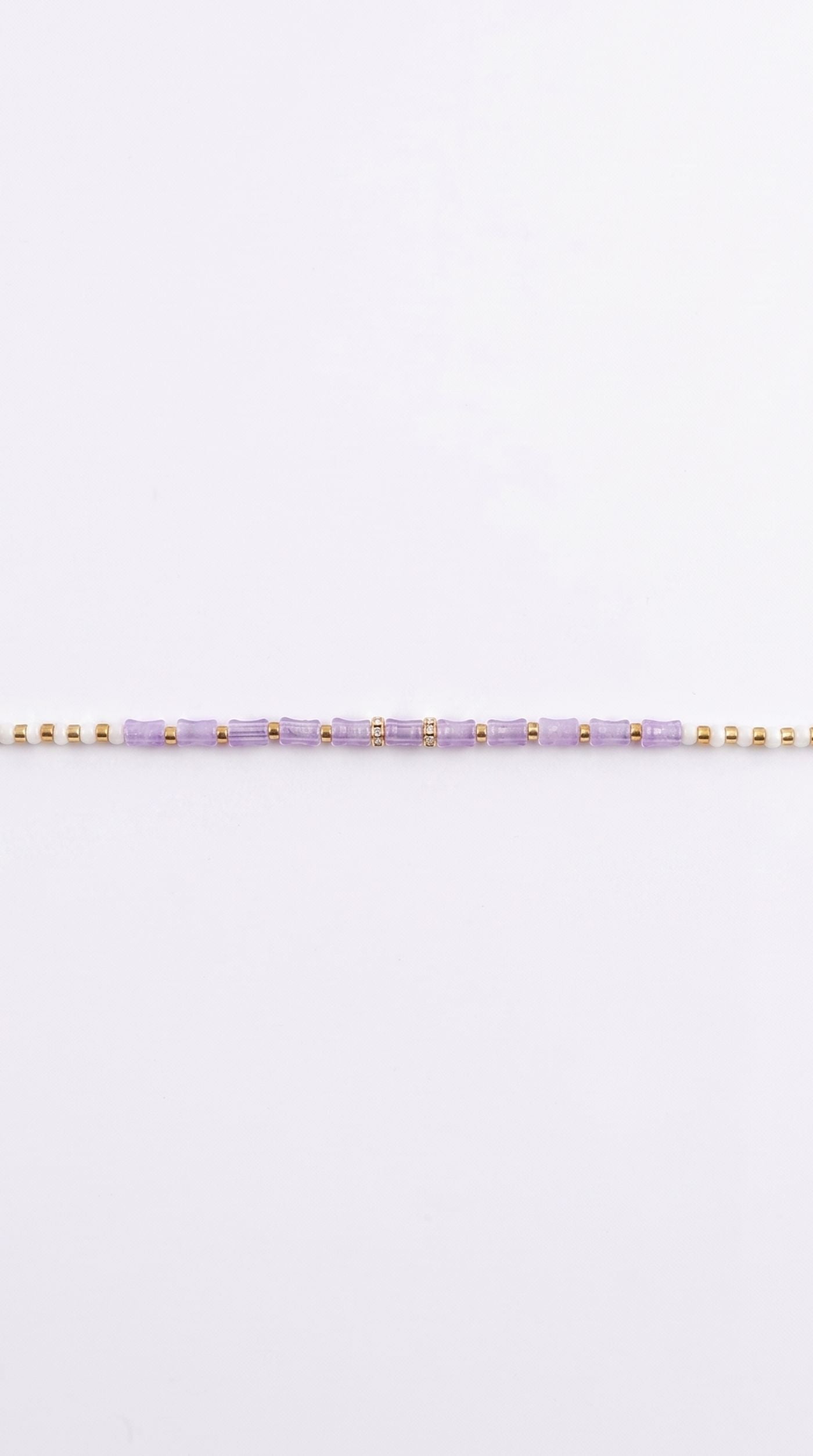 Minimal lavender beaded rakhi bracelet with gold-tone spacer beads and adjustable thread worn on a man's wrist – Diya Online
