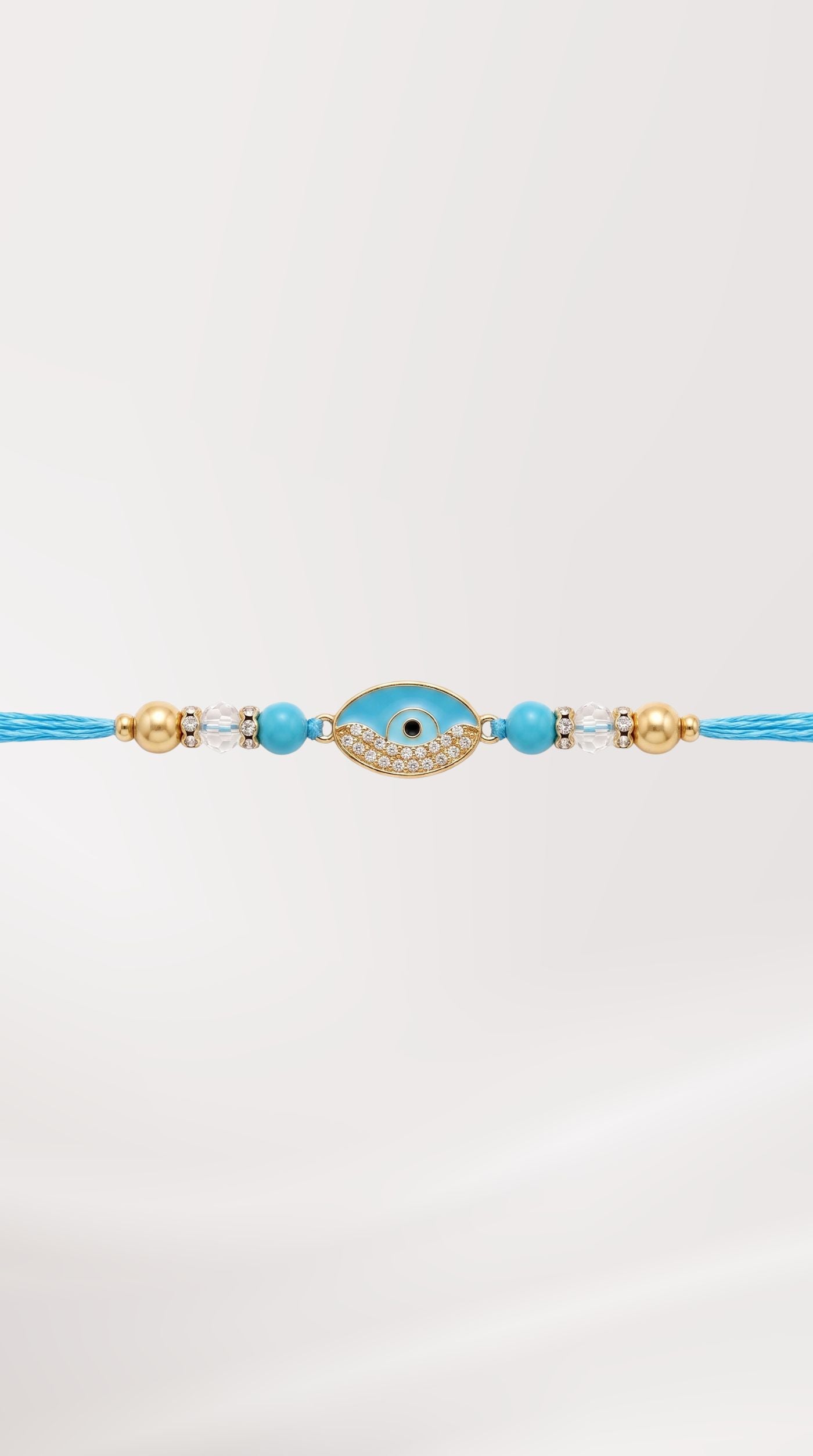 Blue evil eye rakhi bracelet with crystal detailing, blue beads, and adjustable blue thread worn on a man's wrist – Diya Online
