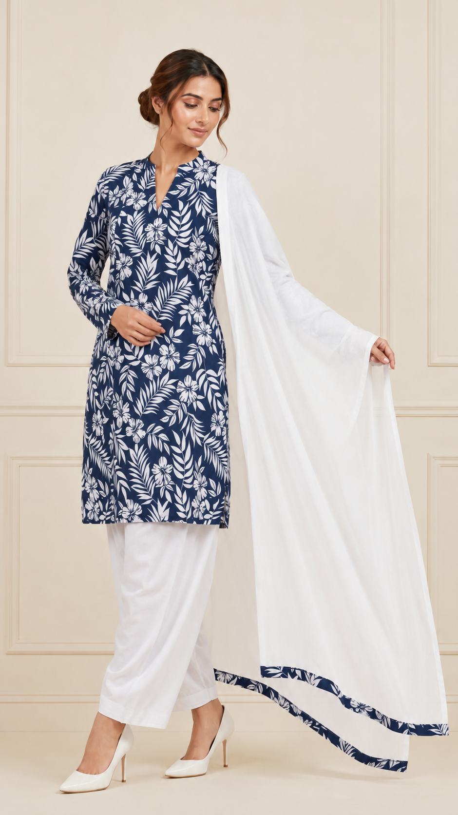 Woman wearing a navy blue and white floral printed kurta set with white trousers and white dupatta – Diya Online ethnic wear.