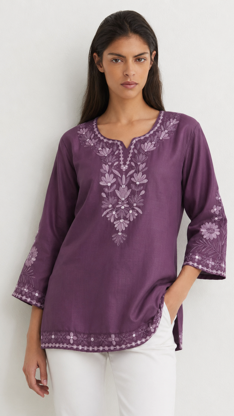 Young woman wearing a purple embroidered kurta top with tonal floral threadwork, three-quarter sleeves and white trousers.