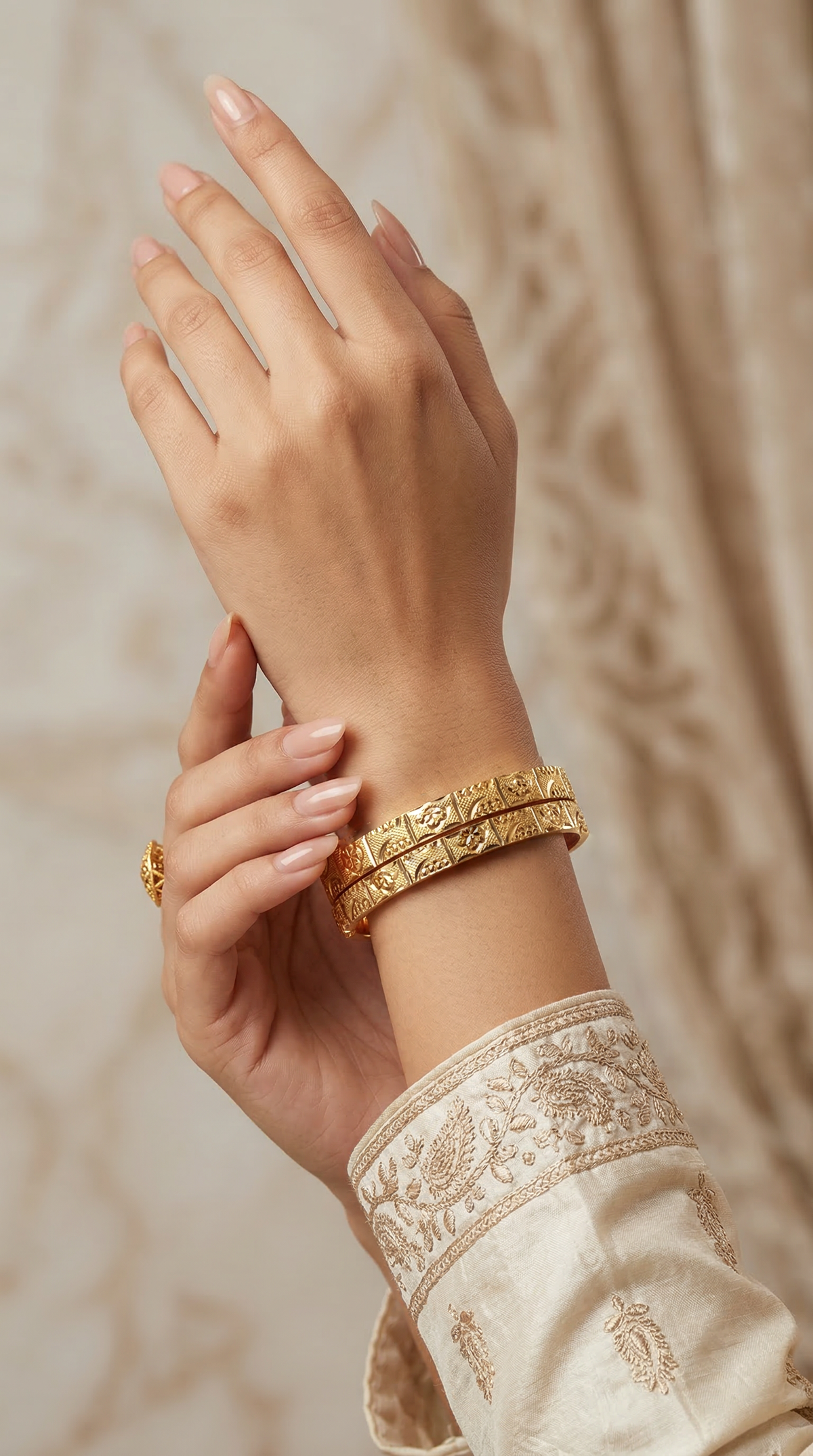Gold bracelet pair with carved design