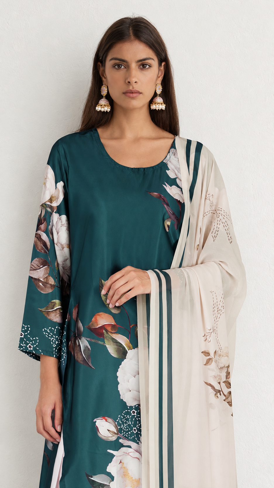 A woman modeling a dark teal green printed kurta with a beige dupatta featuring green stripes and floral motifs, set against a plain off-white background.