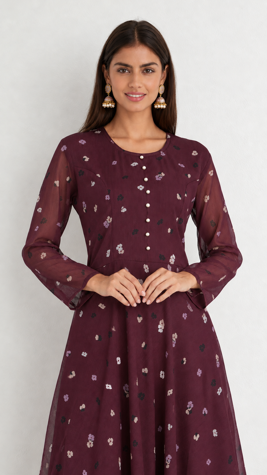 A woman modeling a long-sleeved maroon kurta with a small floral print and buttoned front, set against a plain light gray background.