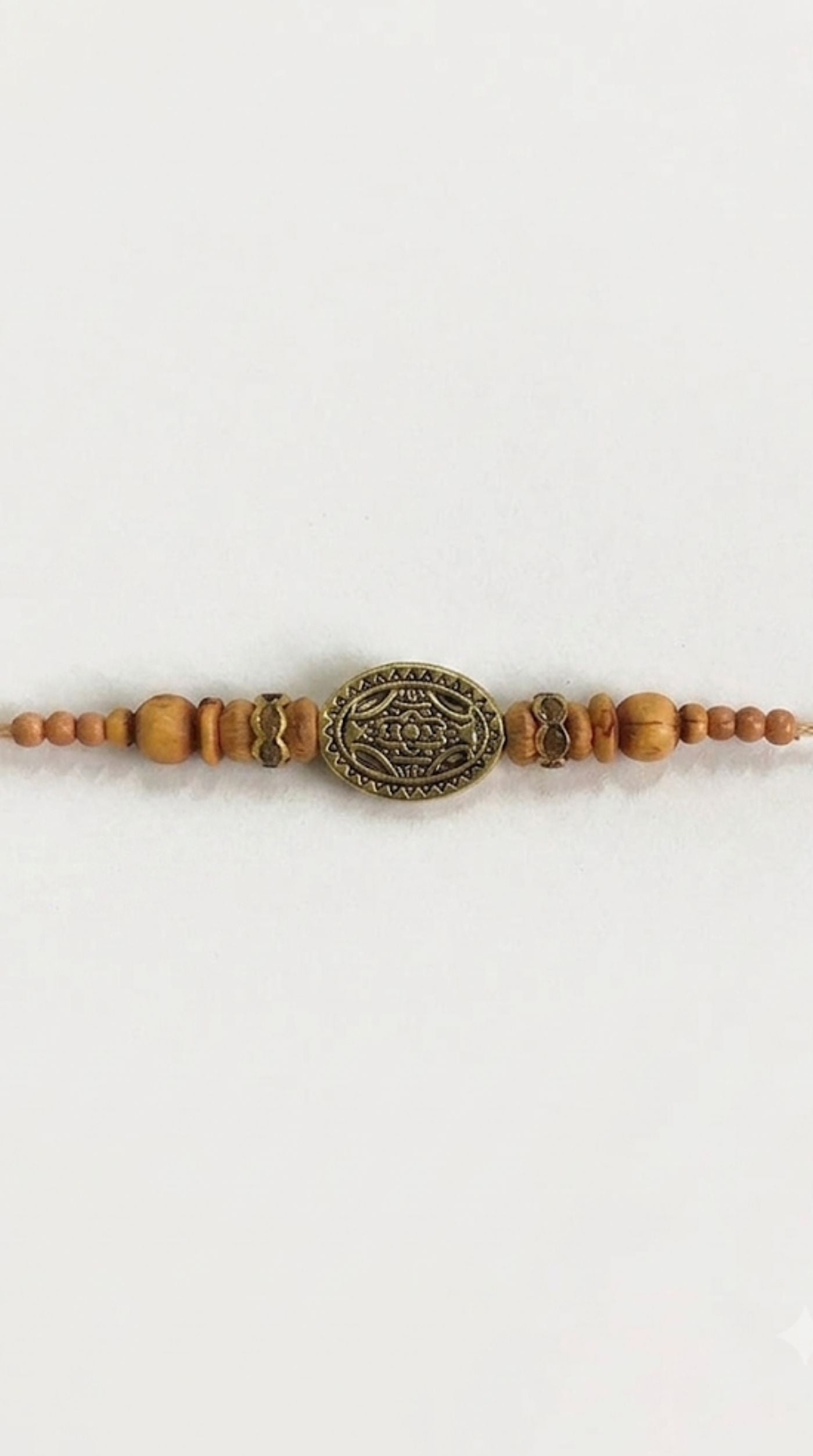 Close-up of wood bead Rakhi with antique gold detailing