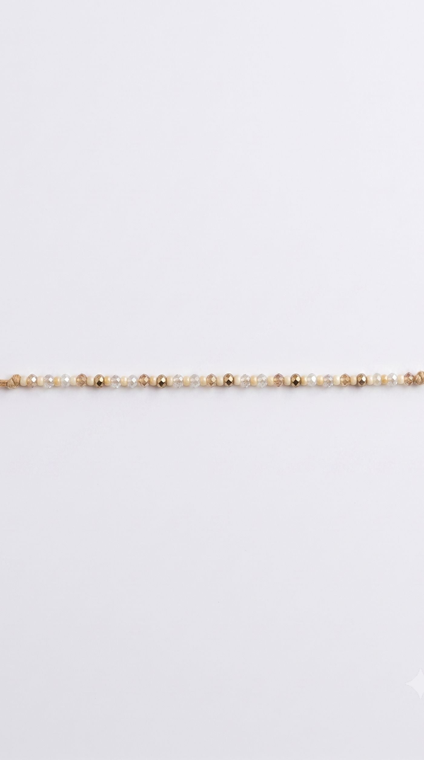 Minimal white pearl beaded rakhi bracelet with silver-tone spacer beads worn on a man's wrist – Diya Online