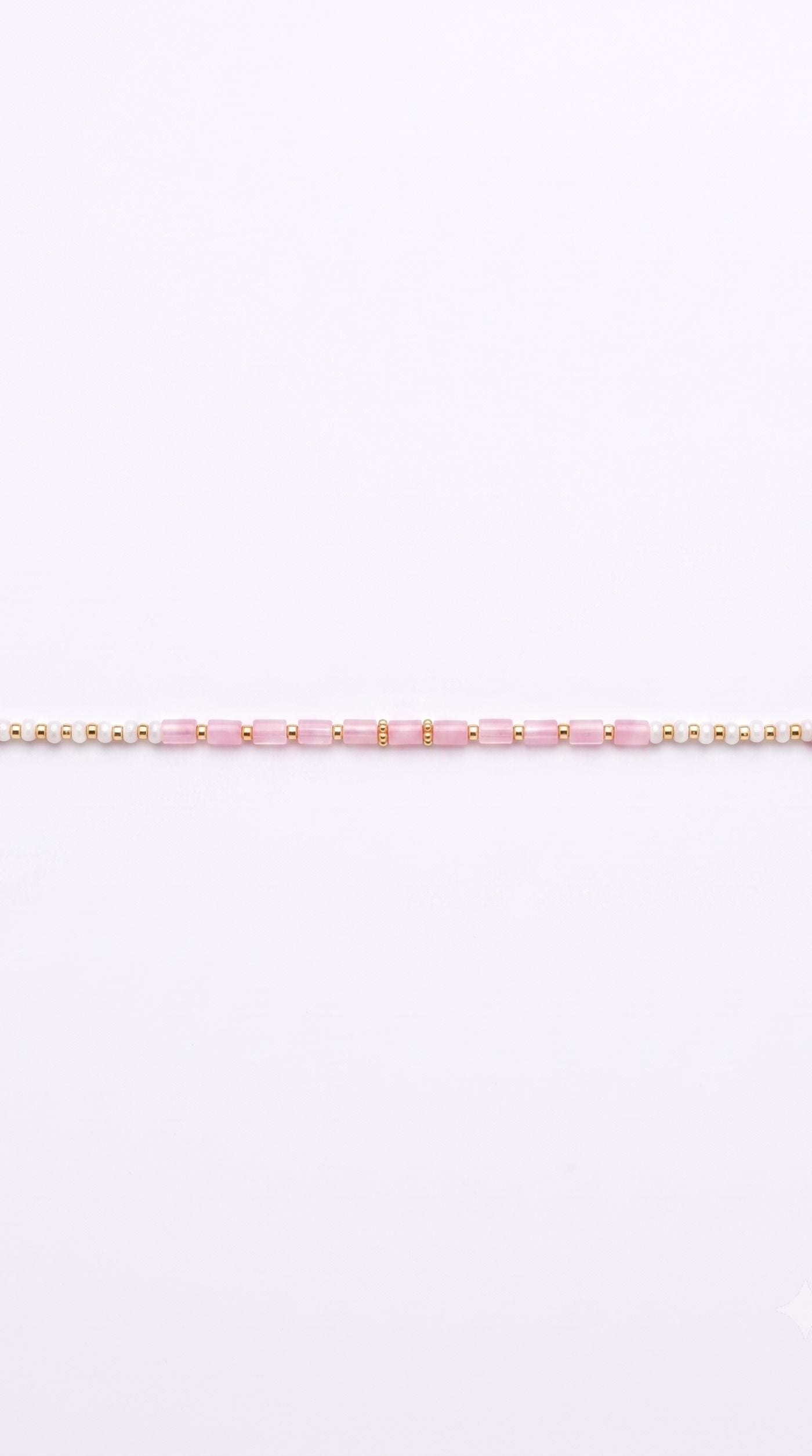 Minimal pink beaded rakhi bracelet with gold-tone spacer beads and matching pink thread worn on a man's wrist – Diya Online