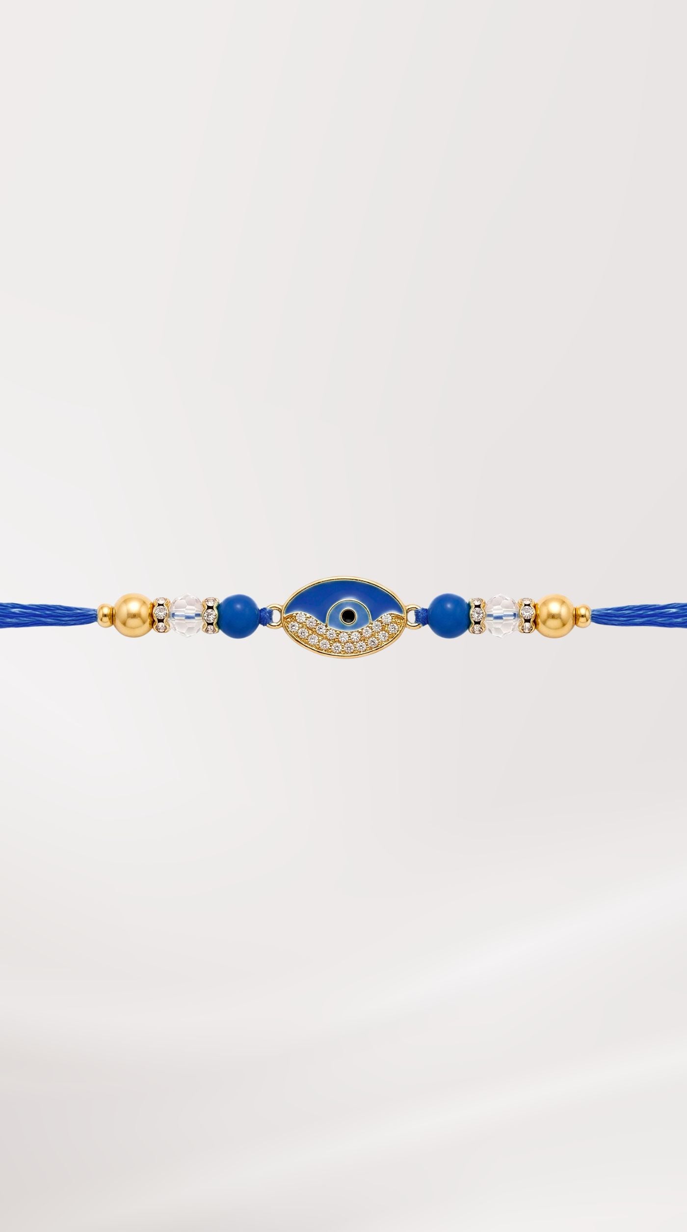 Navy evil eye rakhi bracelet with crystal detailing, faceted blue beads, pearl accents, and adjustable navy thread worn on a man's wrist – Diya Online
