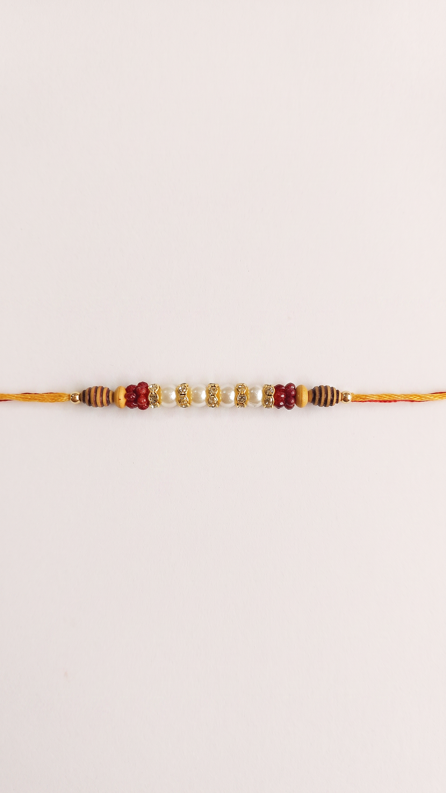 A traditional Indian Rakhi bracelet with gold-colored thread.