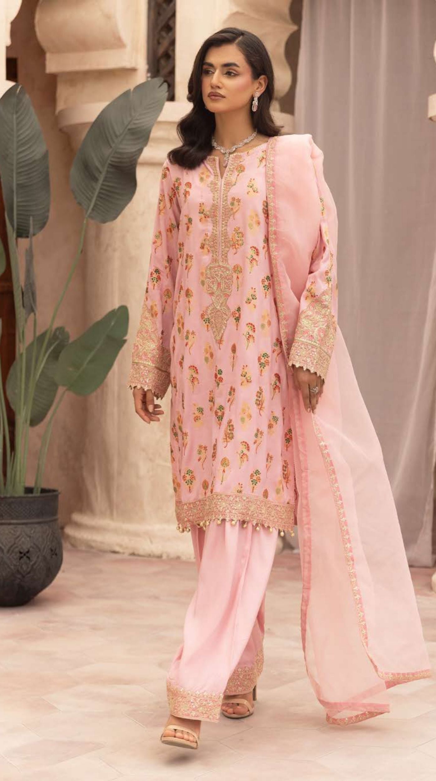 Women's blush pink embroidered viscose suit set featuring floral motifs, embellished cuffs, coordinated bottoms, and a lightweight net dupatta.