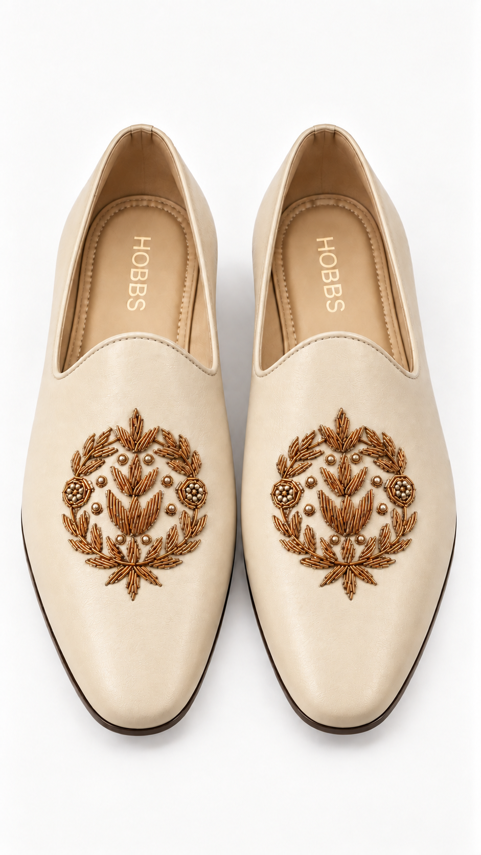 A pair of Hobbes cream-colored leather slip-on loafers with ornate brown and gold floral embroidery on the toe, shown from a top-down view on a white background.